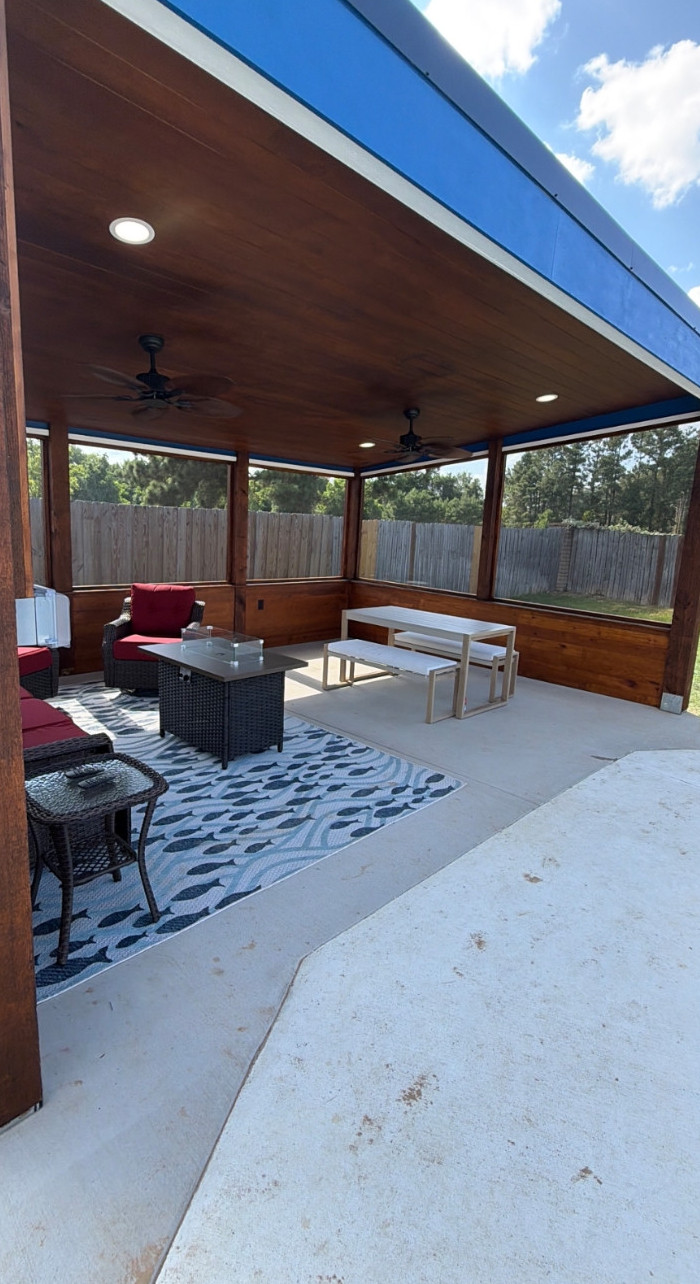 Covered patio with a wood ceiling, ceiling fans, recessed lights, seating and a picnic table.